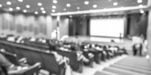 Seminar conference or town hall meeting blur background in auditorium or hotel room with audiences, speaker podium stage and presentation screen for entrepreneurship business speech or community talk